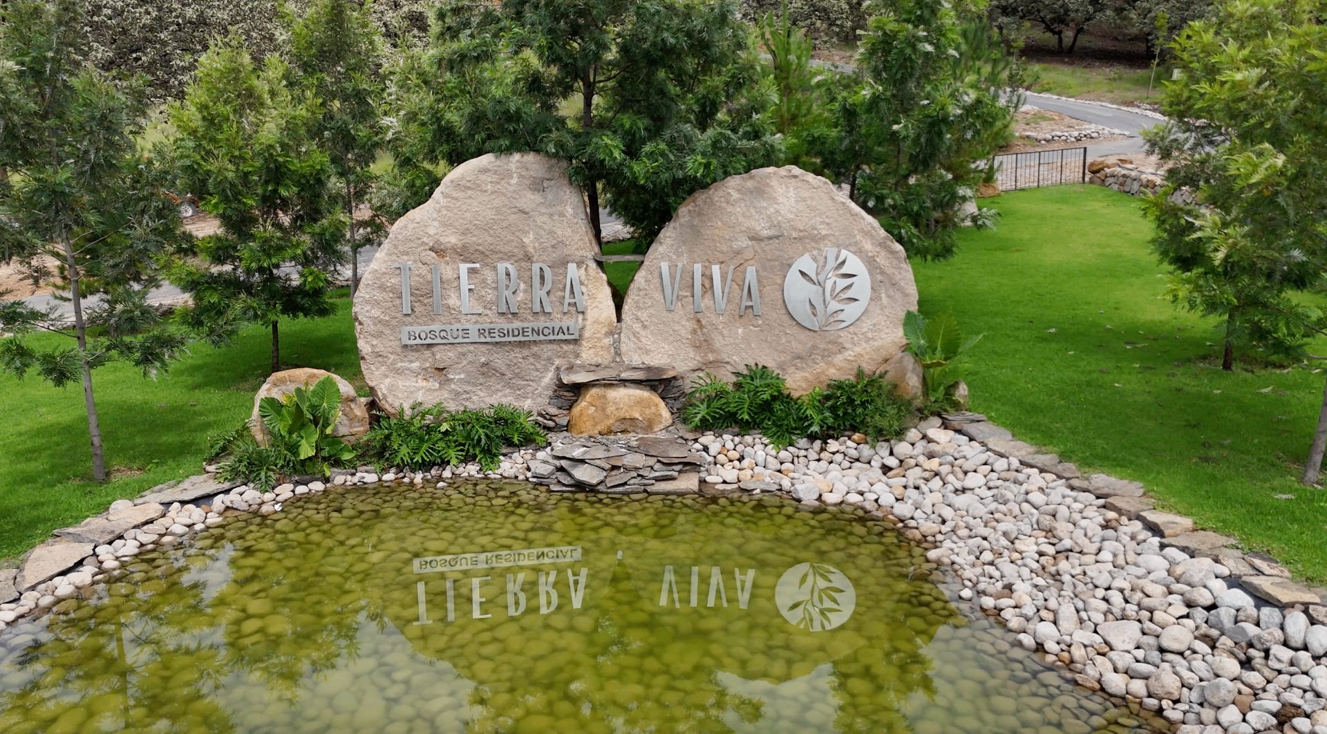 Acceso de Tierra Viva Bosque Residencial con logo físico en piedra