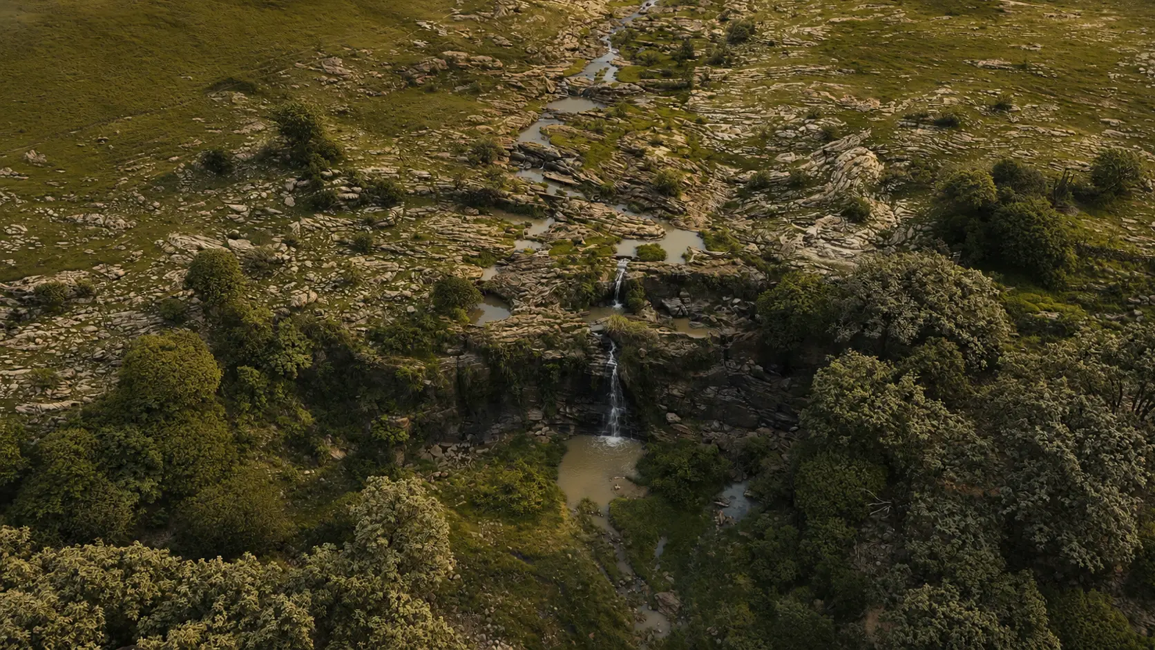 Cascada y arroyo natural entre roca y vegetación, parte del paisaje que rodea a Tierra Viva